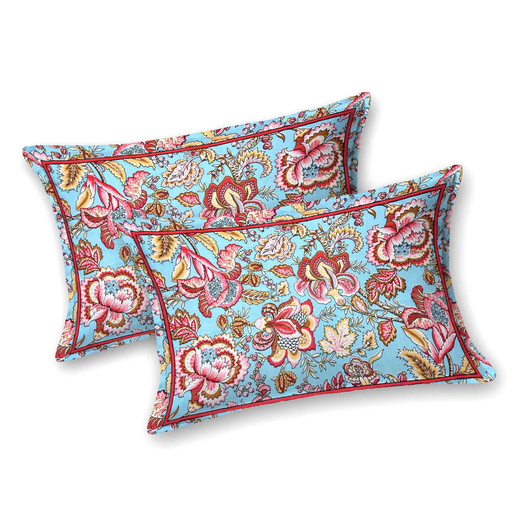 Two aqua blue pillow covers with red and pink Jacobean florals and a thin red border line
