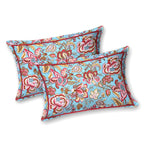 Two aqua blue pillow covers with red and pink Jacobean florals and a thin red border line