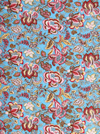 Close-up of large red, pink and mustard Jacobean-style flowers on an aqua sky-blue base