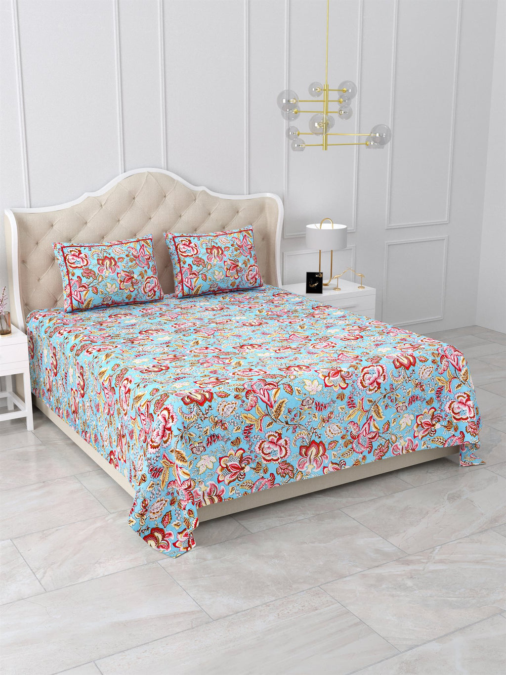 Angled view of the aqua blue floral bedsheet on a bed with matching pillow covers