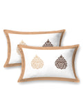 Two white pillow covers with a caramel beige frame and beige & brown damask buta motifs