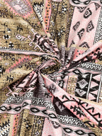 Swirled fabric close-up of beige & pink Aztec and kilim-style geometric print