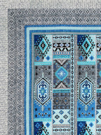 Corner close-up of sky blue, royal blue, aqua and black kilim-style panels and the grey geometric border