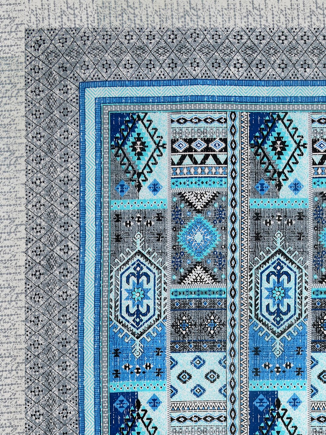 Corner close-up of sky blue, royal blue, aqua and black kilim-style panels and the grey geometric border