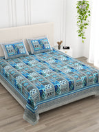 Angled view of the blue & grey Aztec patchwork bedsheet on a bed with 2 pillow covers