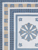 Flat corner close-up of the blue medallion bedsheet showing layered borders and beige panel band