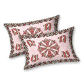 Two blush pink pillow covers with a brown and red mandala medallion and chevron motifs