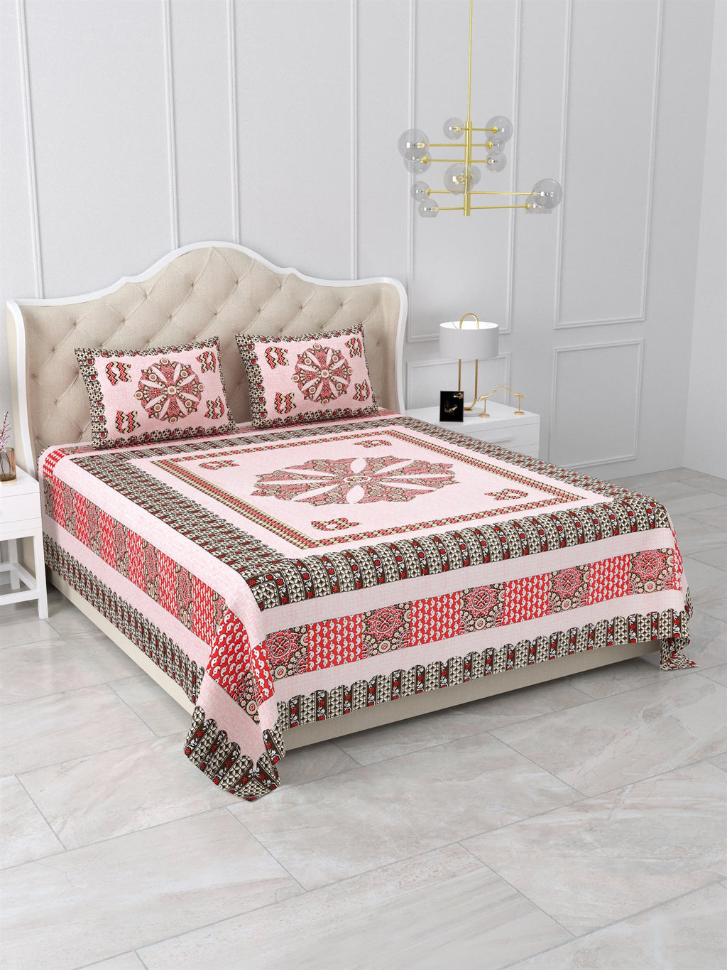 Angled view of the blush pink medallion bedsheet showing red and brown layered side borders