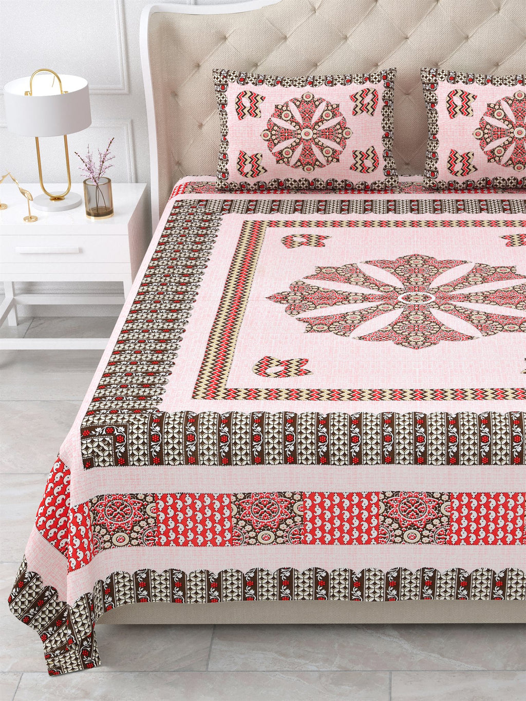 Close view of the pink mandala centre panel and brown and red borders on the bed