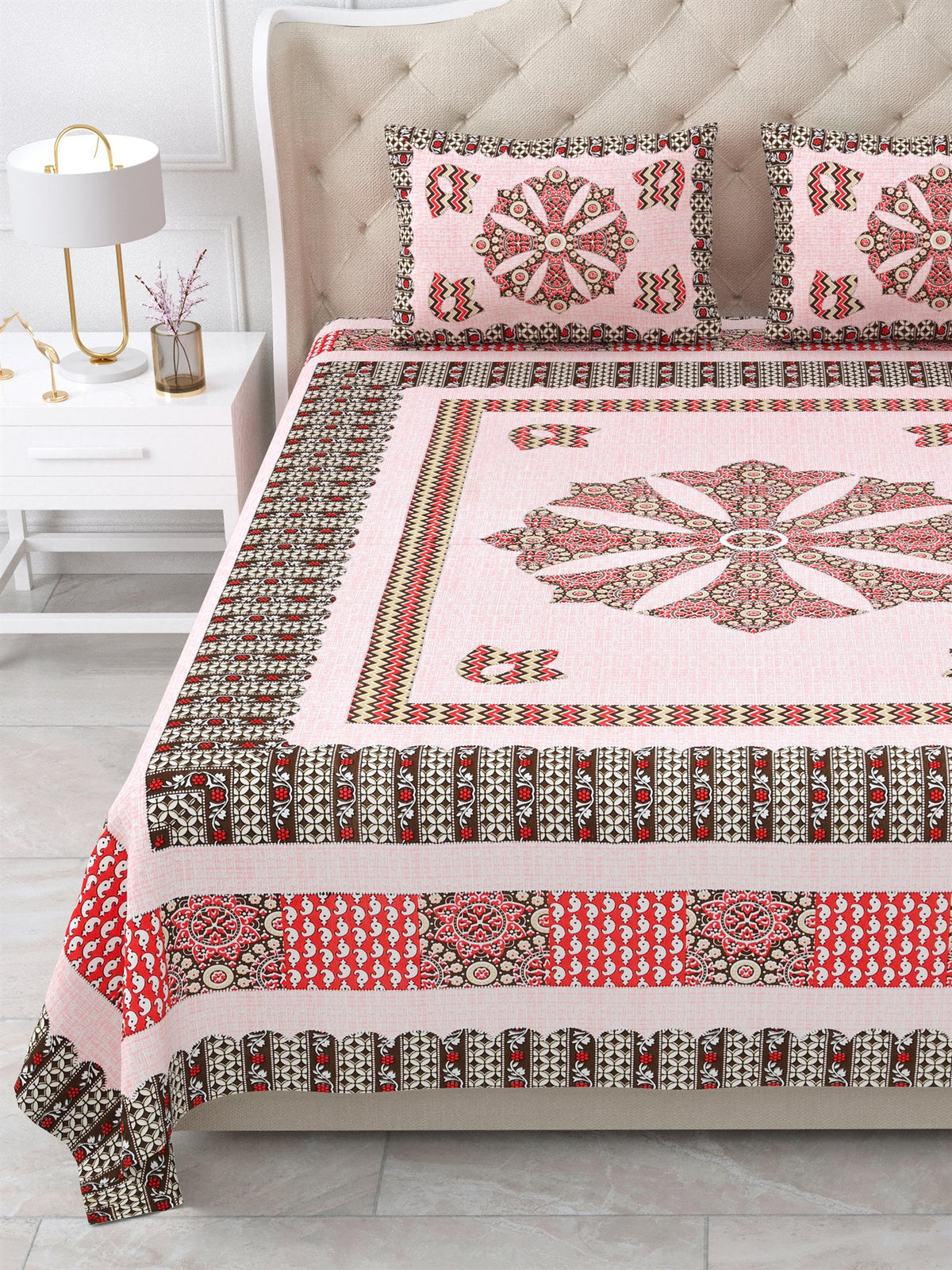 Close view of the pink mandala centre panel and brown and red borders on the bed