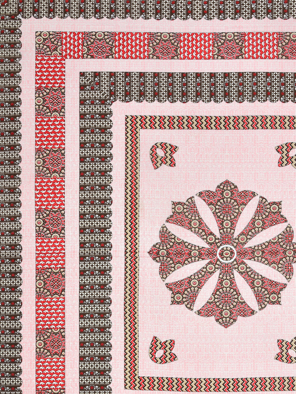 Flat corner close-up of the pink medallion bedsheet showing brown borders and red panel band