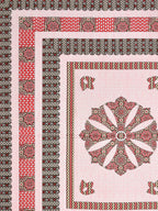 Flat corner close-up of the pink medallion bedsheet showing brown borders and red panel band