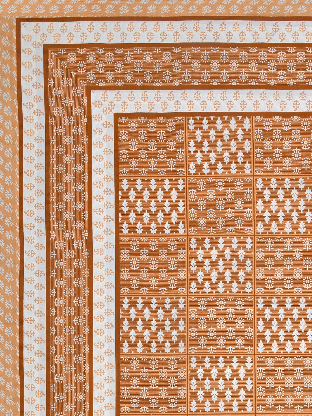 Flat corner view of the burnt orange bedsheet showing the buta grid and layered borders