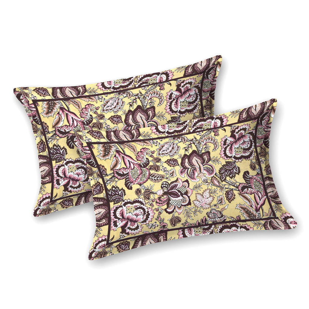 Two butter yellow pillow covers with plum and pink Jacobean florals and a thin dark border line
