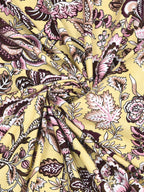 Swirled fabric close-up of plum and pink florals on butter yellow, Castile India bedsheet