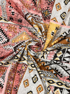 Swirled fabric close-up of coral & mustard Aztec and kilim-style geometric print