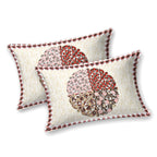 Two cream pillow covers with a maroon, rust and pink quartered leaf medallion and check edge