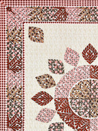 Flat corner close-up of the leaf mandala and maroon leaf border on a cream lattice base