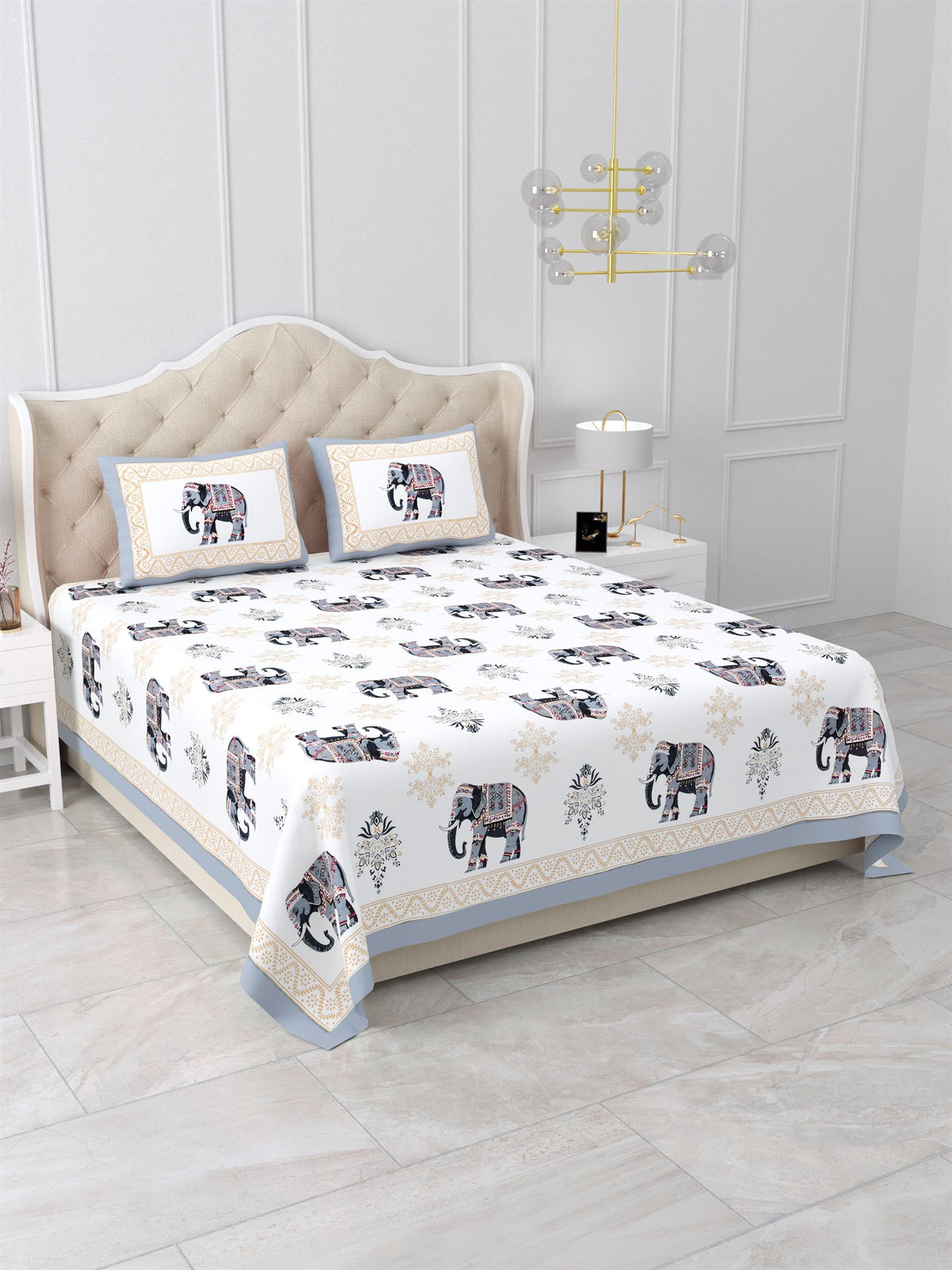 Angled view of the grey & beige elephant print bedsheet on a bed with 2 pillow covers