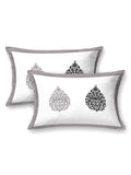 Two white pillow covers with a grey frame and grey & black damask buta motifs