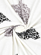 Swirled fabric close-up of grey & black damask buta print on white