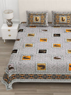 Close view of orange and black peacock patches and the ornamental border on the grey bedsheet