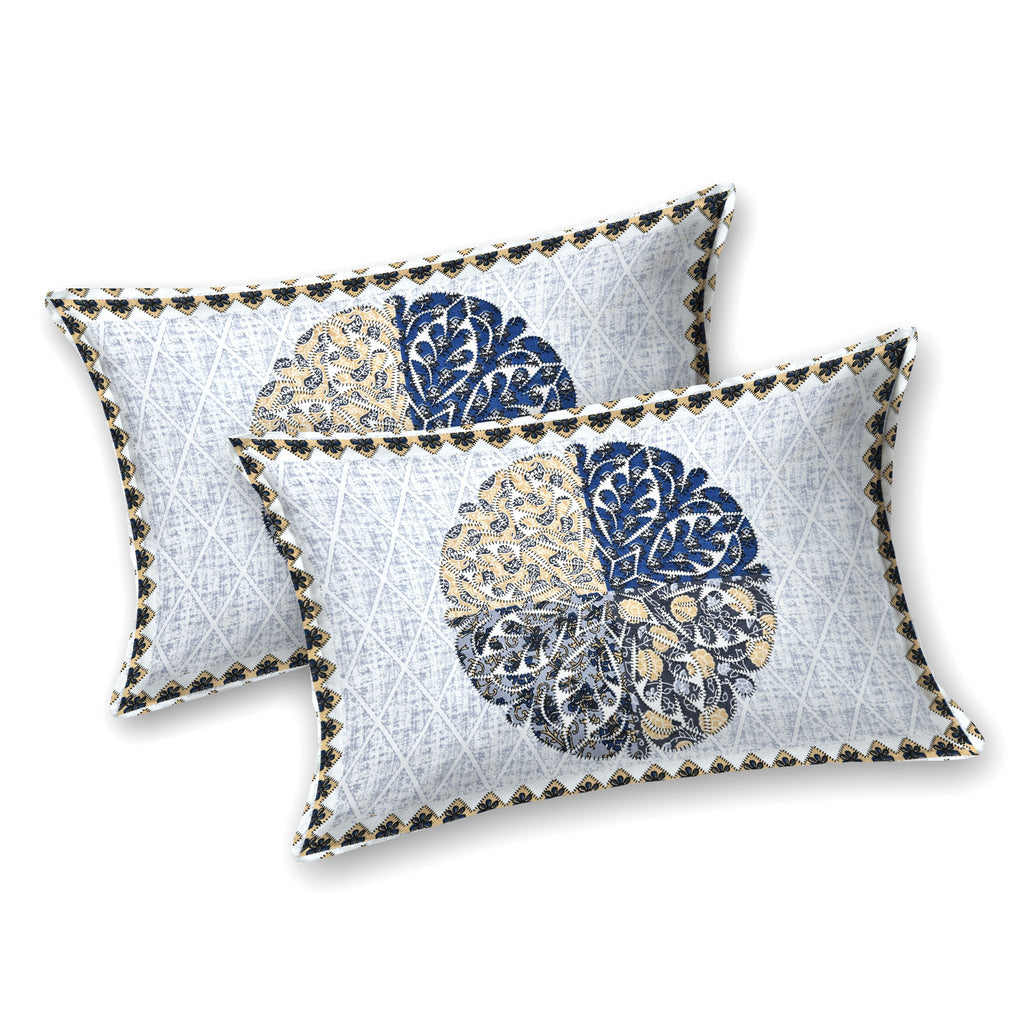 Two white pillow covers with an indigo and beige quartered leaf medallion and triangle-check edge