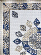 Flat corner close-up of the leaf mandala and indigo leaf border on a white lattice base