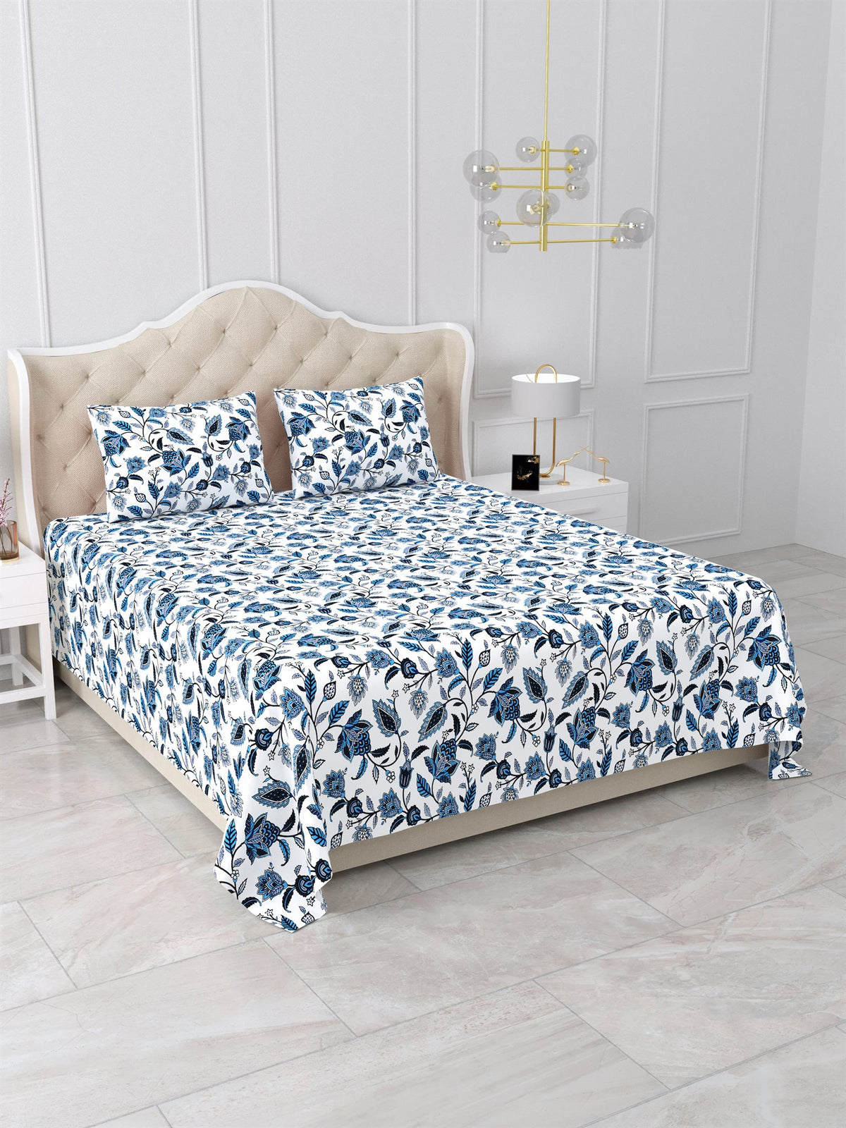 Angled view of the blue and white floral vine bedsheet on a bed