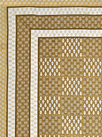 Flat corner view of the mustard bedsheet showing the buta grid and layered borders