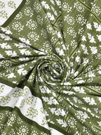 Swirled fabric close-up of white leaf and flower butas on an olive green striped background