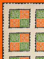 Flat corner view of the cream bedsheet with orange and green square blocks and a solid orange border