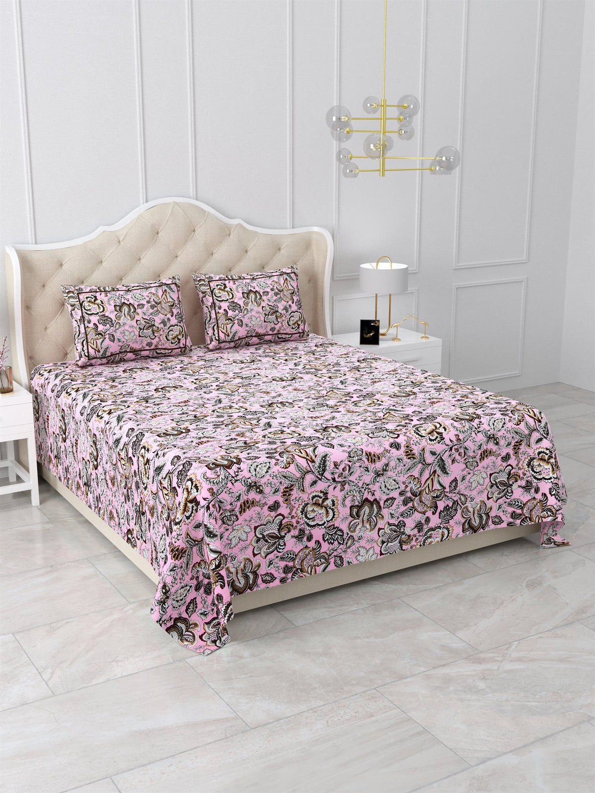 Angled view of the pink floral bedsheet on a bed with matching pillow covers