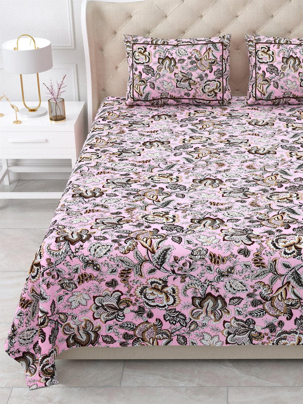 Close view of the pink and brown floral bedsheet and pillow covers on the bed
