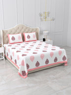 Angled view of the pink & maroon damask buta bedsheet on a bed with 2 pillow covers