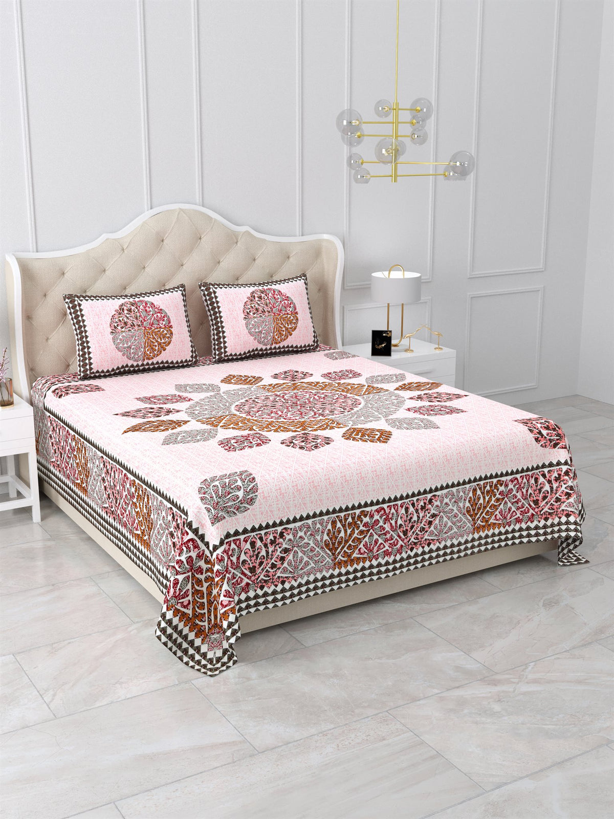 Angled view of the pink leaf mandala bedsheet showing the maroon leaf-motif side border