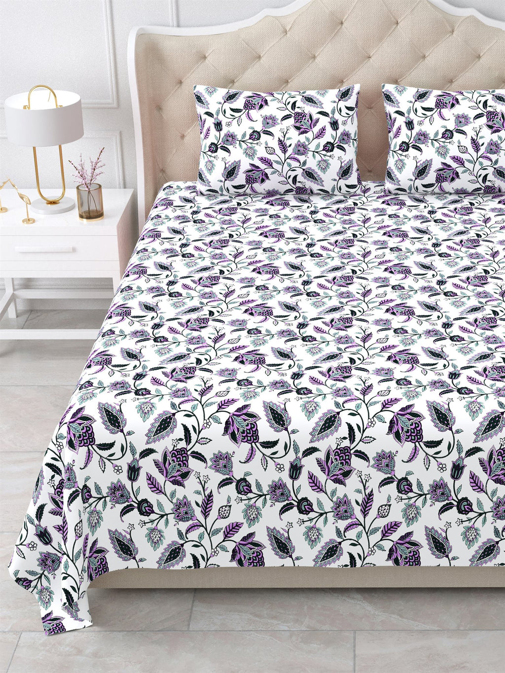 Close view of the purple and lavender floral vine bedsheet and pillow covers on the bed