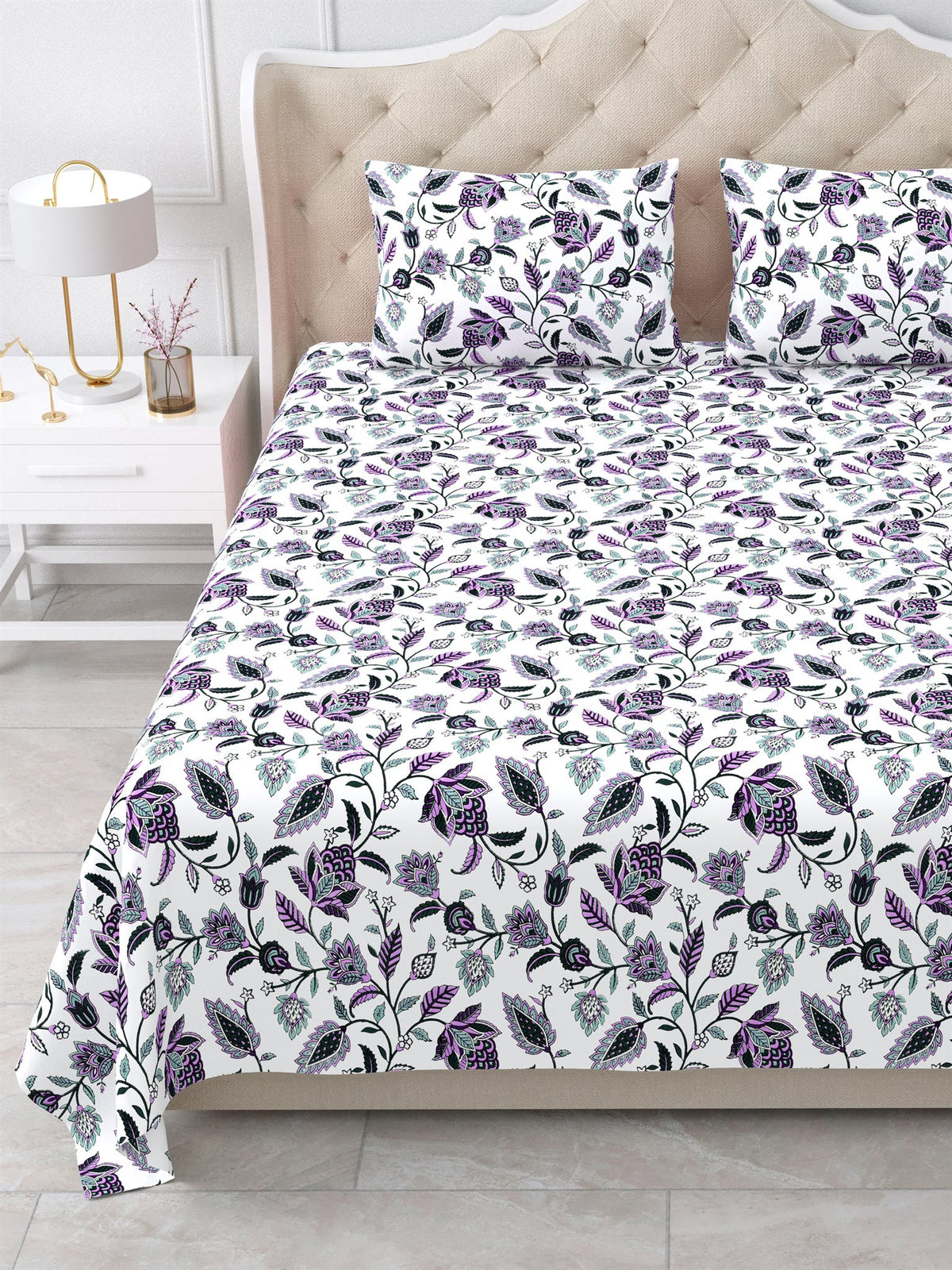 Close view of the purple and lavender floral vine bedsheet and pillow covers on the bed