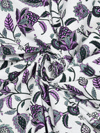 Swirled fabric close-up of purple, lavender and deep green floral vines on a white base
