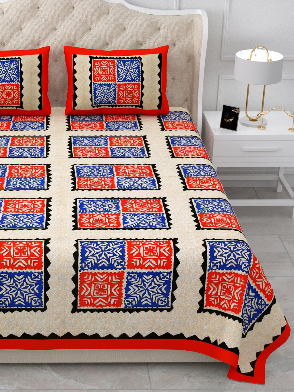 Close view of red and royal blue square blocks with black zigzag frames on the bed