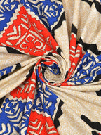 Swirled fabric close-up of red and blue cut-work style tiles on a cream base