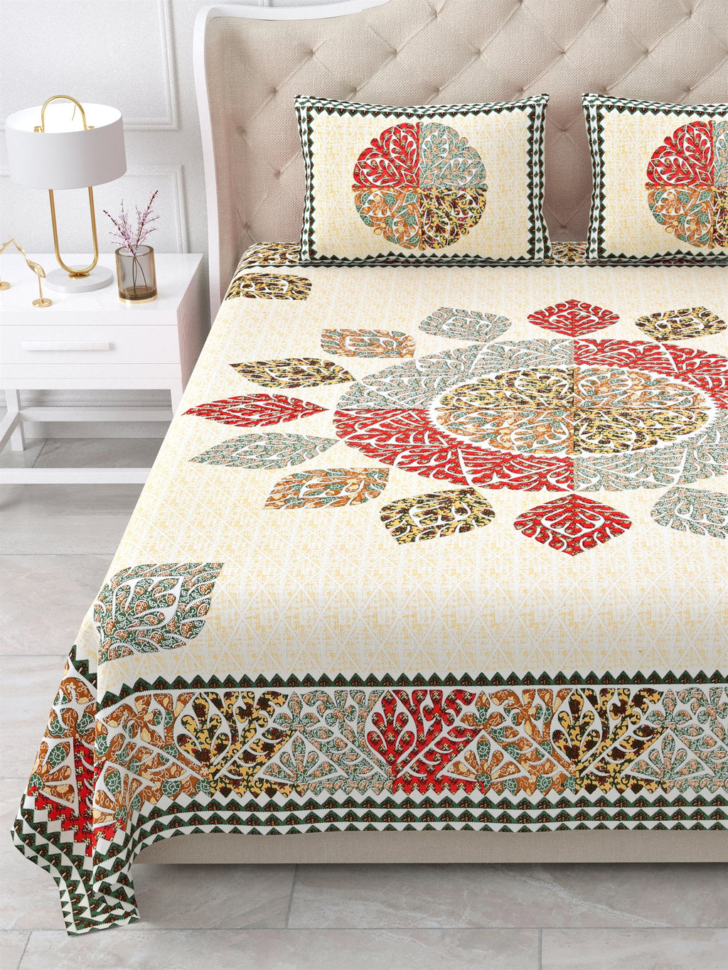 Close view of the red, sage and ochre leaf mandala and border on the bed