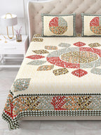 Close view of the red, sage and ochre leaf mandala and border on the bed