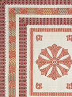 Flat corner close-up of the rust medallion bedsheet showing layered borders and mustard panel band