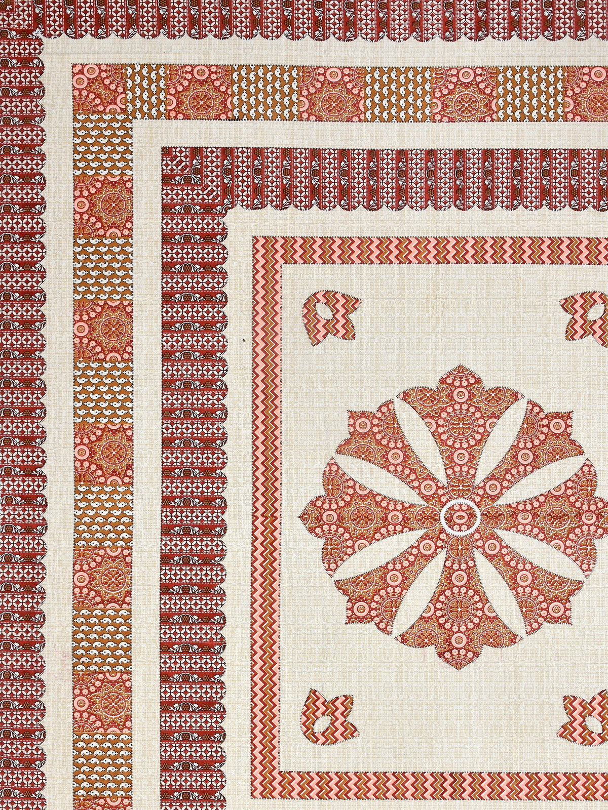 Flat corner close-up of the rust medallion bedsheet showing layered borders and mustard panel band