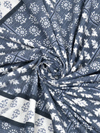 Swirled fabric close-up of white leaf and flower butas on a slate blue striped background