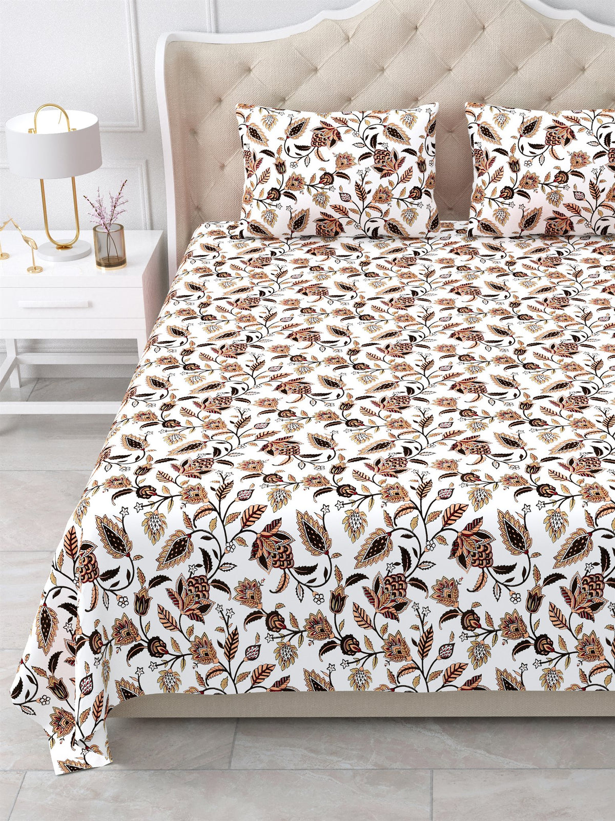 Close view of the rust and brown floral vine bedsheet and pillow covers on the bed